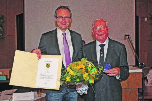 Gerhard Heitmann (re.) wurde von Bürgermeister Dirk Seidler für sein langjähriges Engagement im Gemeinde- und Ortsrat mit der silbernen Münze der Gemeinde Rosengarten ausgezeichnet