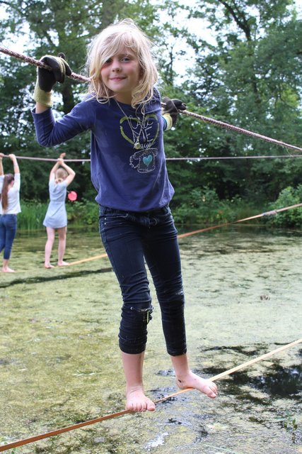 Balance und Körperbeherrschung zeigt Pauline (9) auf der Slackline über dem Teich