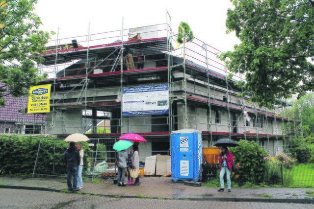 Die Richtkrone schwebt über dem Dach des Mehrfamilienhauses an der Carl-Hermann-Richter-Straße