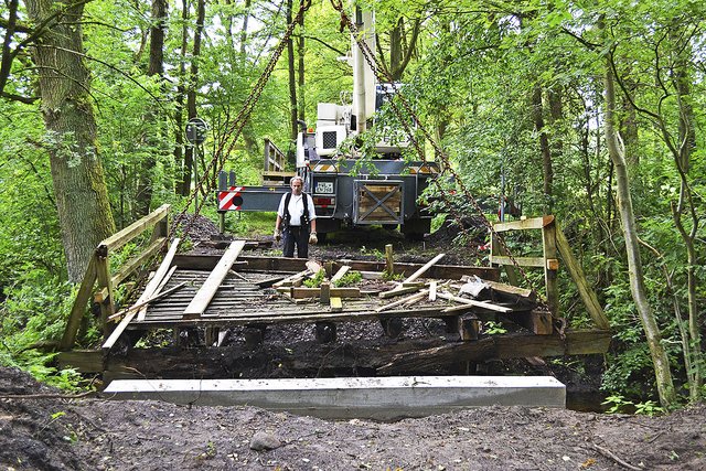 Zimmerer Peter Hinrichs hinter der alten Brücke, die mit dem Kran abgehoben wurde