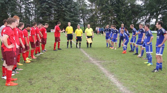 Nach dem Finalspiel: Beide Teams - TV Welle (li.) und TSV Heidenau mit dem Schiedsrichter-Trio auf dem Rasenplatz in Wistedt