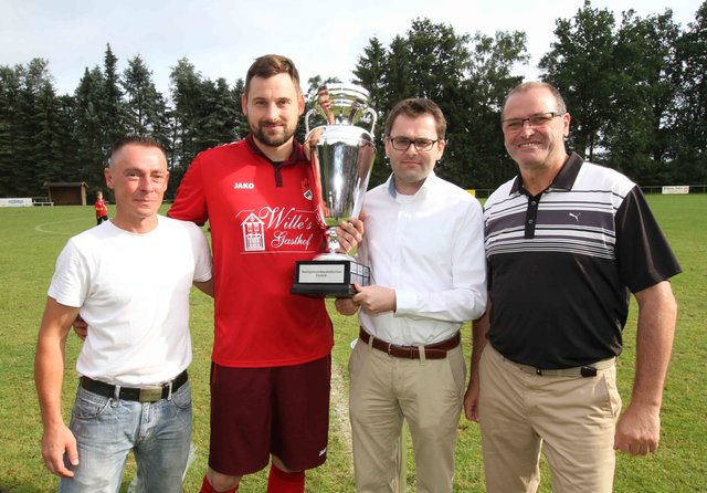 Pokalübergabe mit den Gastgebern des Ausrichters SV Wistedt (v.l.): Harry Ditman, Welles Mannschaftsführer Claas Nelke, Vize-Samtgemeindebürgermeister Rolf Aldag, und Wistedts Vereinsvorsitzender Ingo Martin