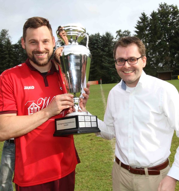 Tostedts Vize-Samtgemeindebürgermeister Rolf Aldag (re.) übergibt den Siegerpokal an Welles Mannschaftskapitän Claas Nelke