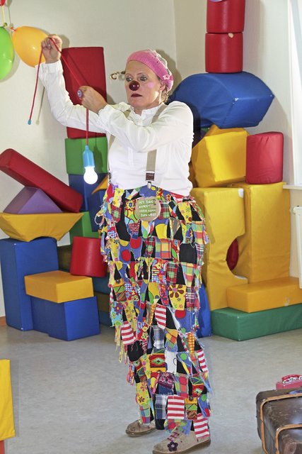 Spaßmacherin Zappalotta mit einer Glühbirne