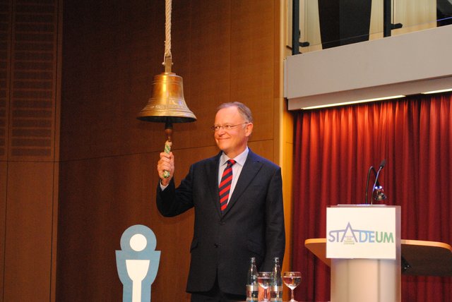 Stefan Weil schlägt zur Eröffnung des Holk Kulturfestivals sieben Mal eine Schiffsglocke