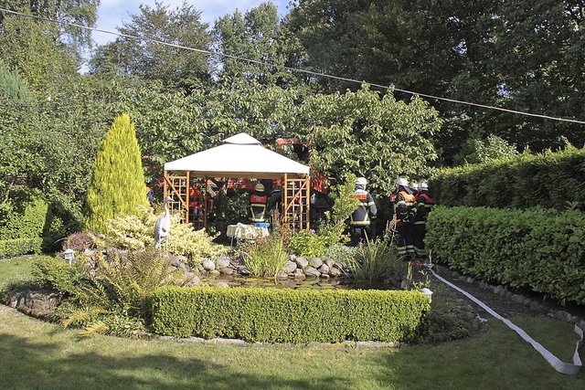 Feuerwehrmänner beim Einsatz im Garten