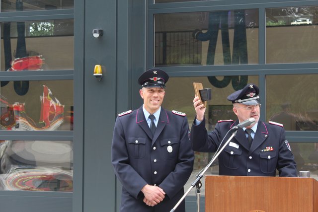 Ortsbrandmeister Joachim Röhrs würdigt stellvertretend für den Einsatz der Feuerwehr beim Bau des neuen Domizils den Kameraden Karsten Spiller