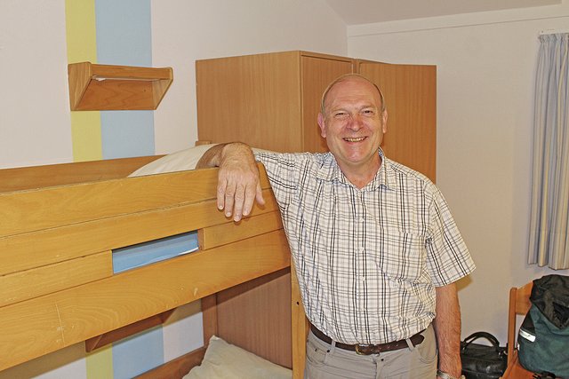 Hans-Günter Isphording in seinem Zimmer. Etagenbetten und Gemeinschafts-Bäder machen ihm nichts aus