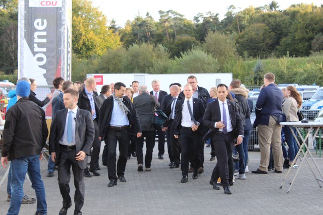 Die Kanzlerin im Anmarsch - vor lauter Sicherheitskräften kaum zu erkennen