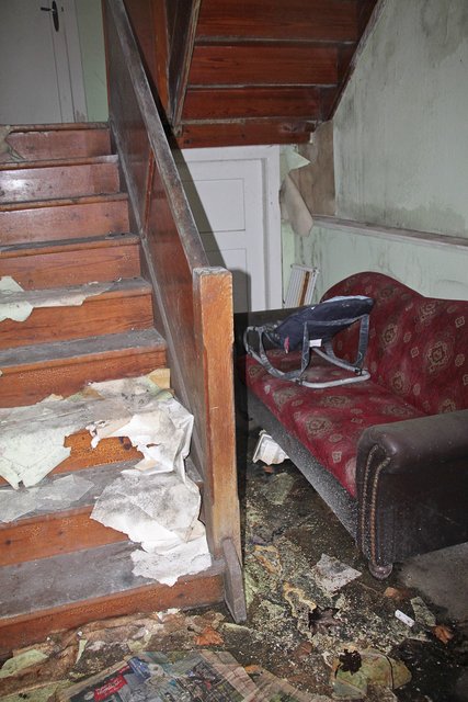 Das leerstehende Haus steht offen. Vom Bürgersteig aus können Passanten in das Treppenhaus schauen