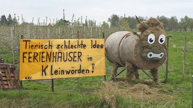 Pfingstochse aus Stroh und ein Protestschild im Frühjahr | Foto: Thorsten Lüllau
