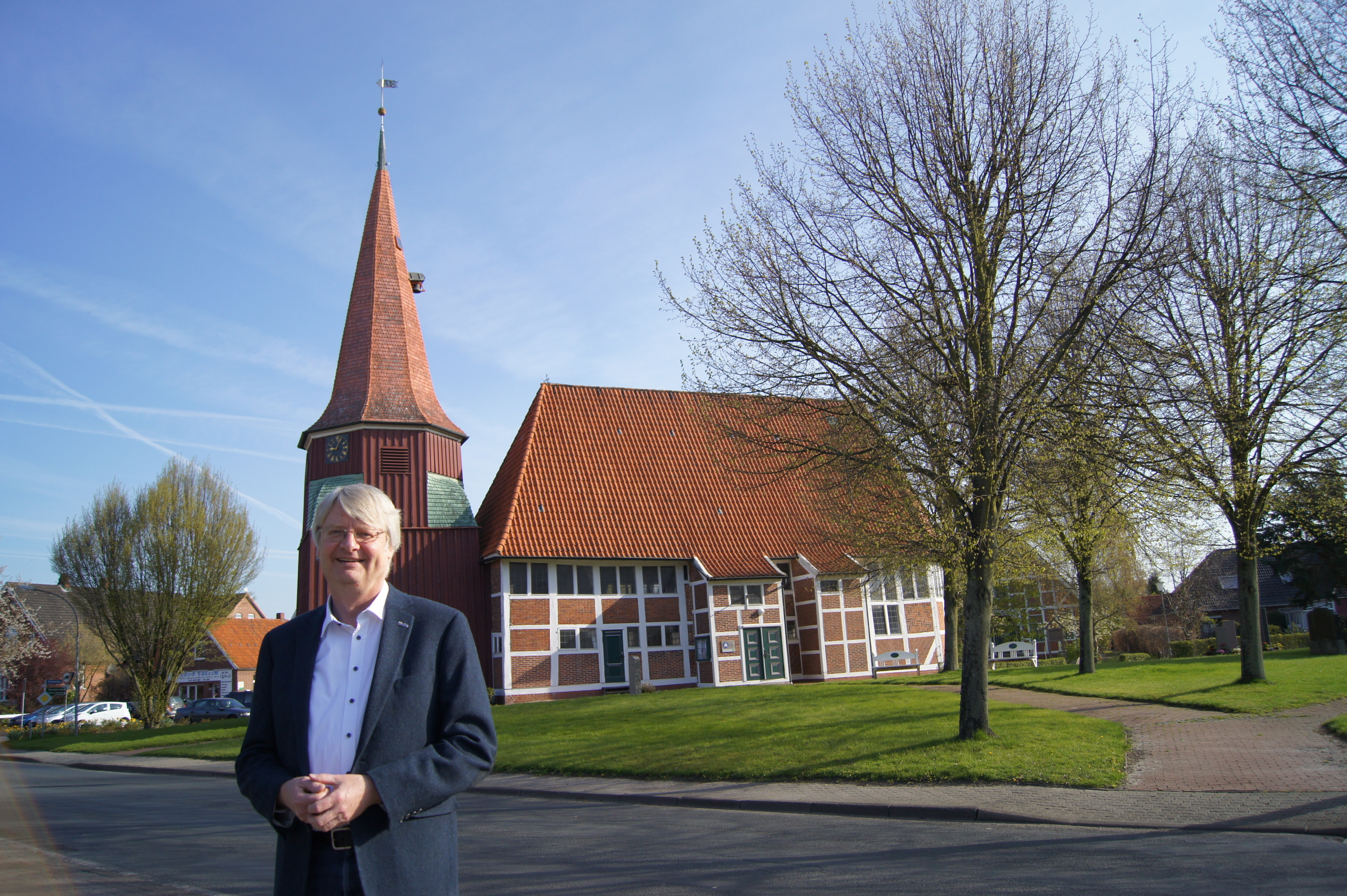 Pastor Uwe Junge vor der Kirche in Grünendeich