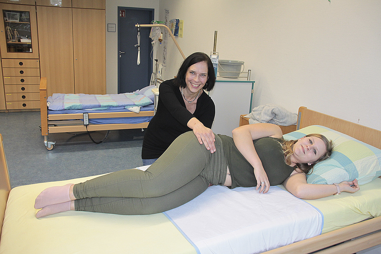Die Lagerung von Patienten gehört zur Ausbildung: Pflegelehrerin Elke Czymoch mit Schülerin Jessica Ihben im Schulungsraum der BBS II in Stade