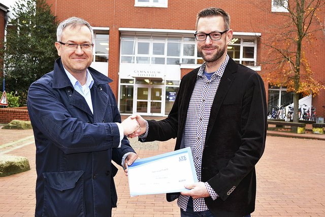 Gymnasiumsleiter Stefan Birkner (li.) händigt Robert Wollenheit das Zertifikat als autorisiertes Testzentrum für verschiedene Toefl-Tests aus