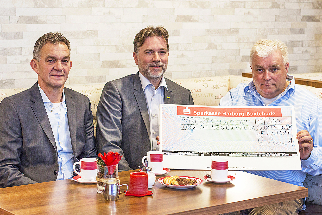 Kay Gosebeck (re.) und Andre Grote (Mitte) überreichen den Scheck gemeinsam an Hartmut Peters vom Dr. Neucks-Heim