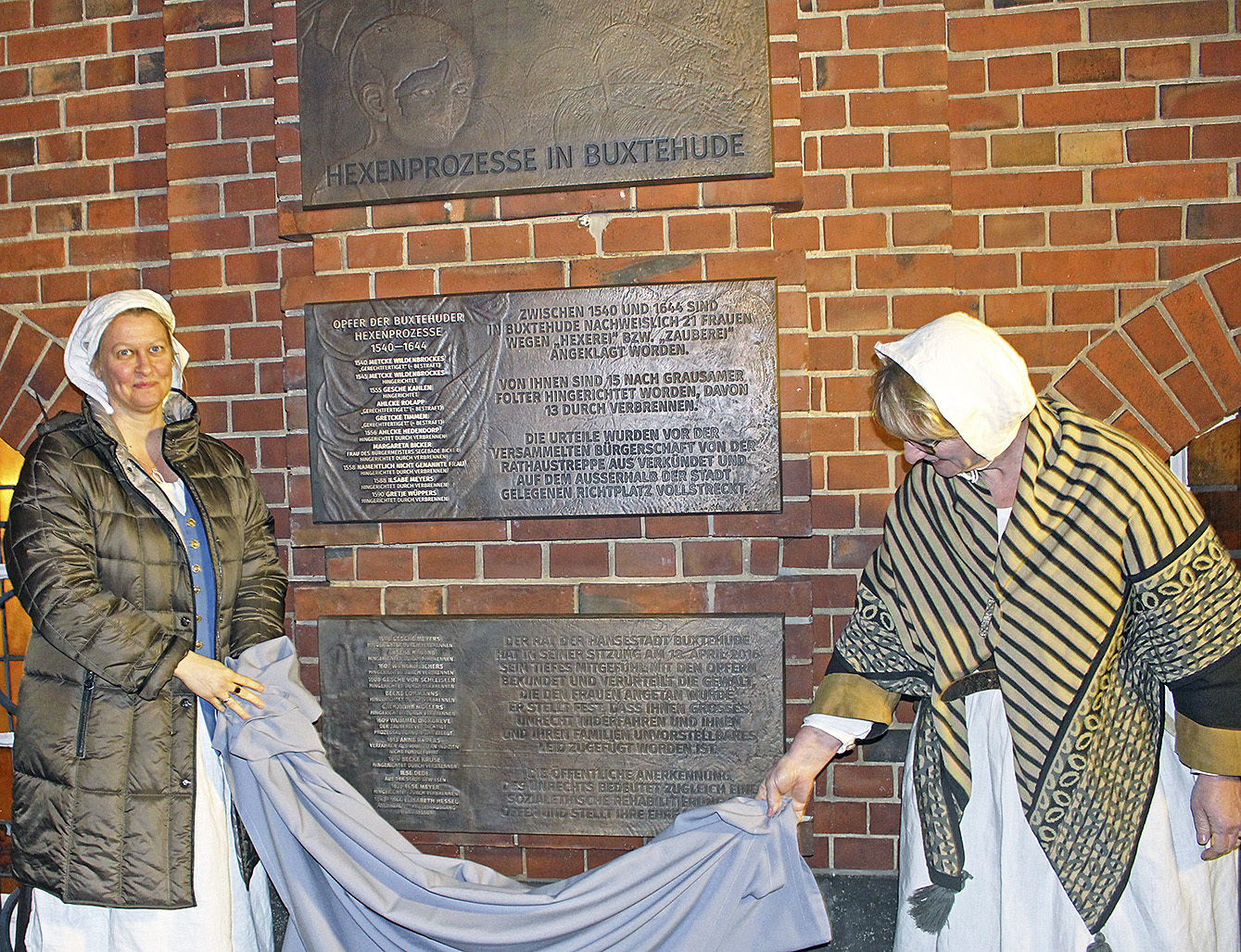 Die Gästeführerinnen Sonja Kaiser (li.) und Marlies Hauschildt enthüllen das Mahnmal "Hexenprozesse in Buxtehude"