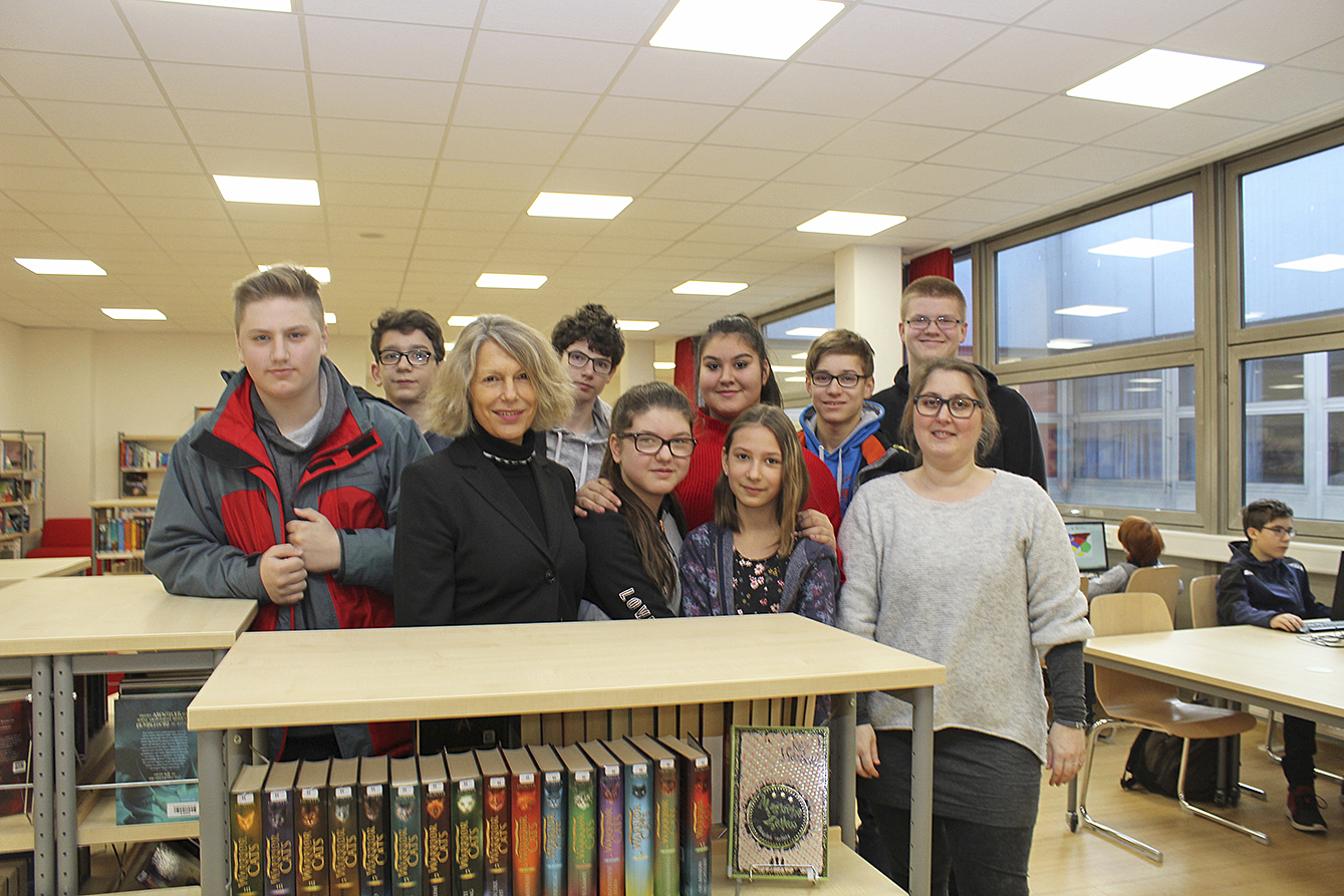 "Das Herz der IGS"; Schulleiterin Christine Holst-Hakelberg mit einigen Schülerinnen und Schülern in der Bibliothek