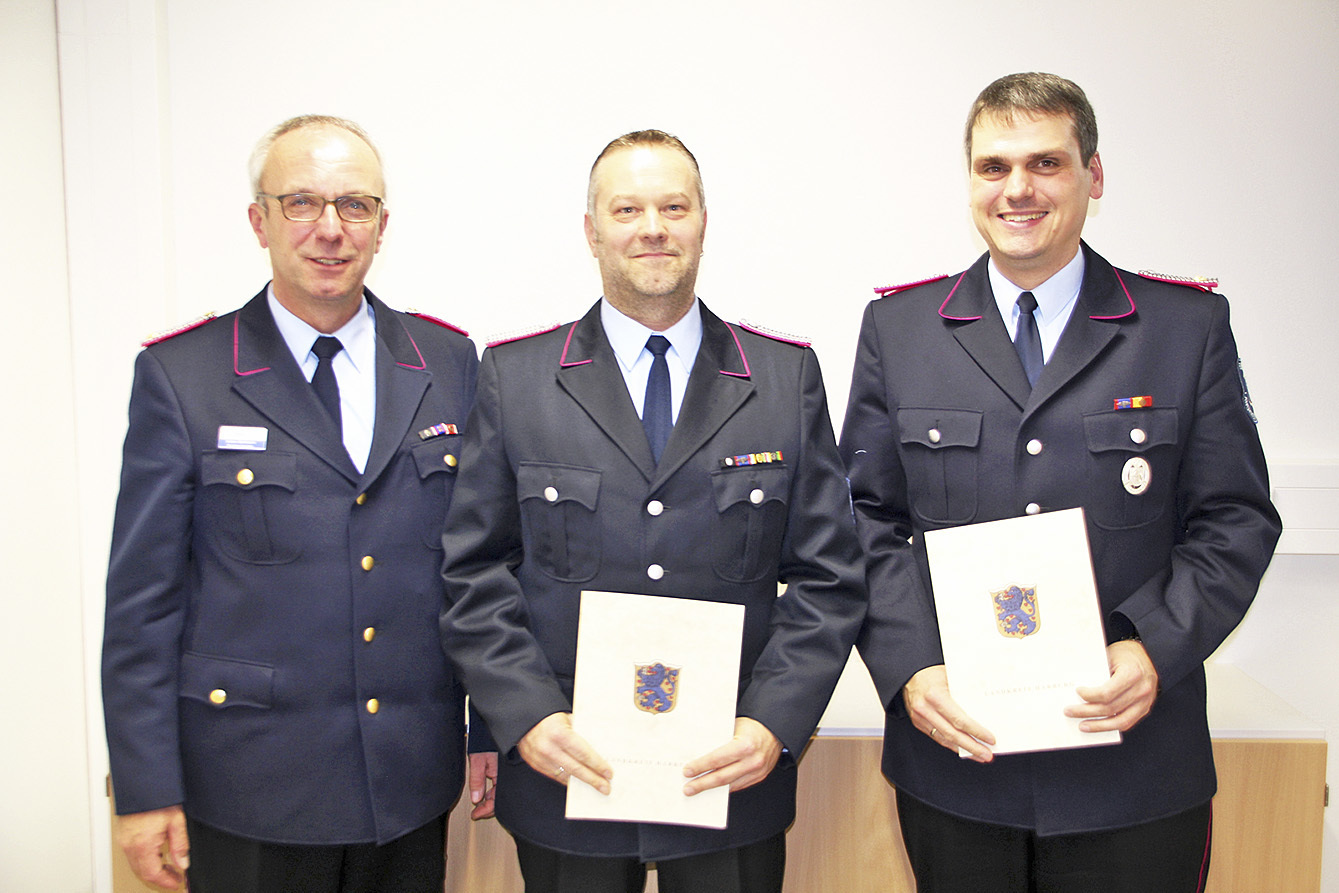 Kreisbrandmeister Volker Bellmann (li.) beförderte Stephan Schick (re.) und Martin Heidtmann