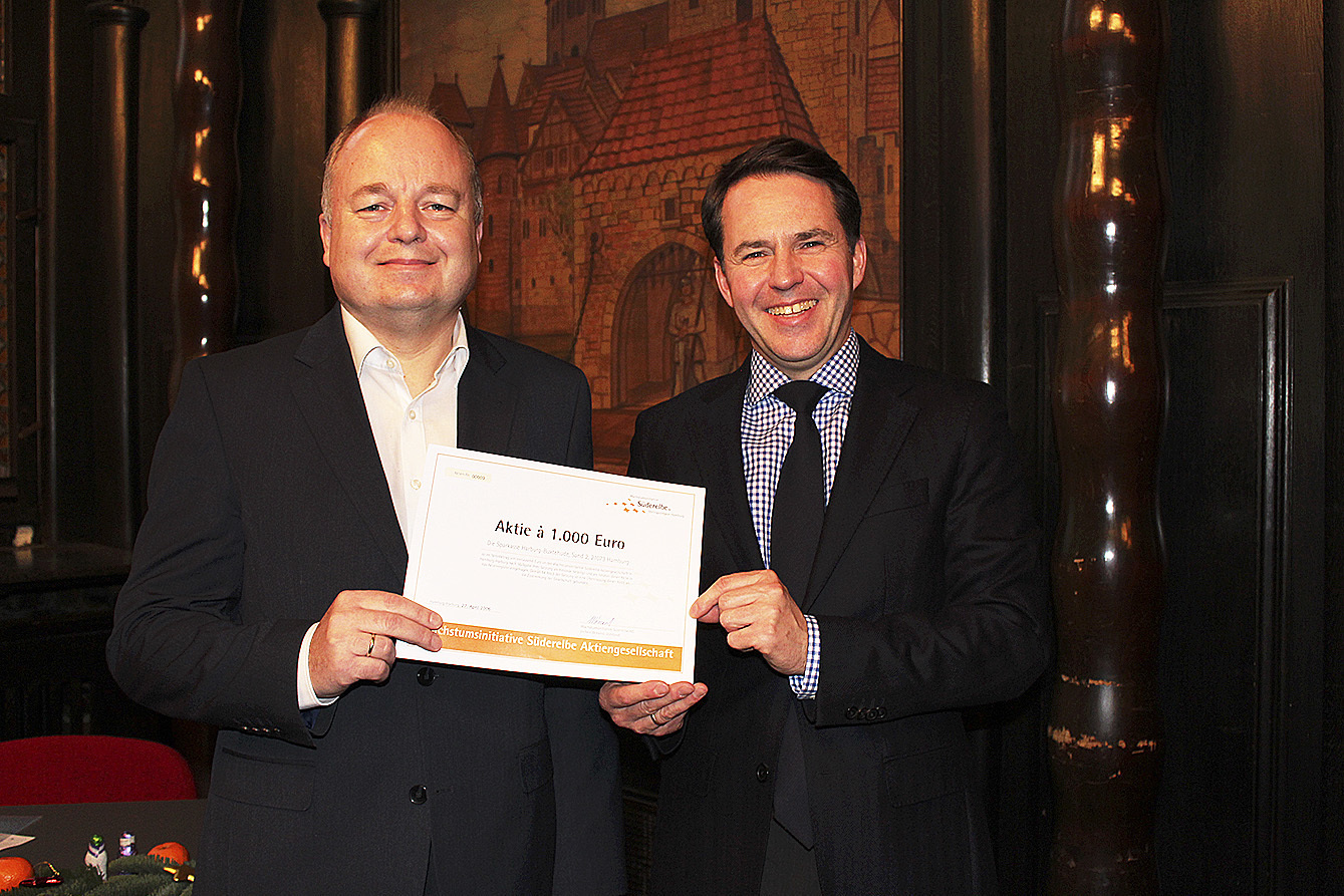 Uwe Fricke (li.) erhält von Dr. Olaf Krüger die Aktie der Süderelbe AG