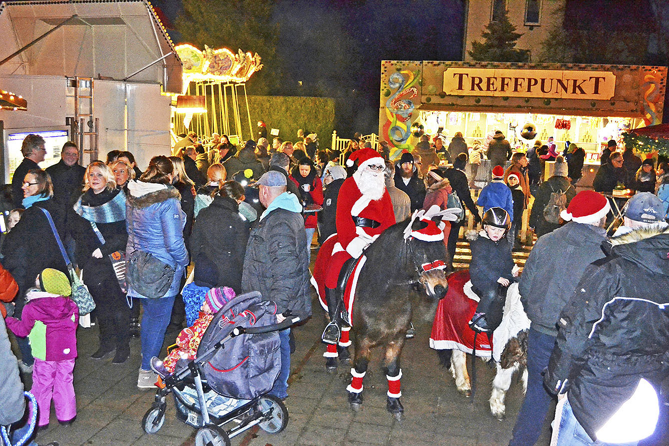 Celine (19, im Weihnachtsmann-Kostüm) und Connor (3, re. daneben) statteten dem Markt mit den ebenfalls geschmückten Ponys "Tamino" und "Ida" einen Besuch ab