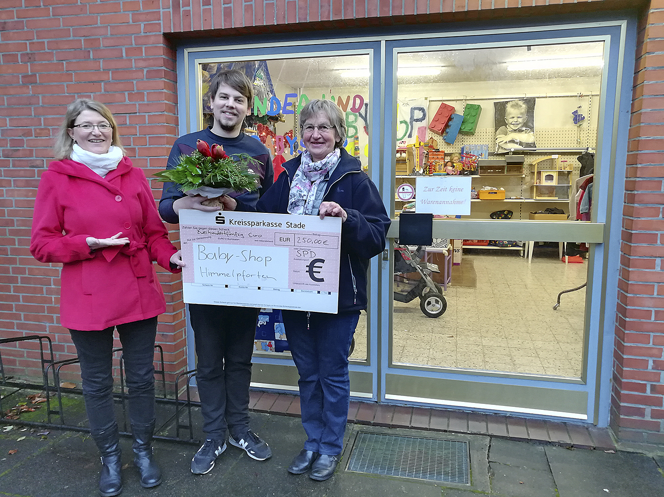 Scheckübergabe: Arne Zillmer und Maike Necke (beide SPD) mit Irmtraut Lawnitzak vor dem Kinder- und Baby-Shops