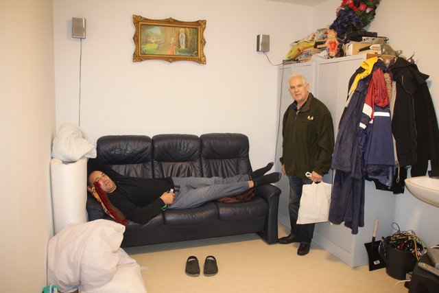 Der Zwei-Meter-Hüne Valeri Zimmermann schläft auf der Dreiercouch: Bürgermeister Horst Deede (re.) will ihm ein langes Bett besorgen