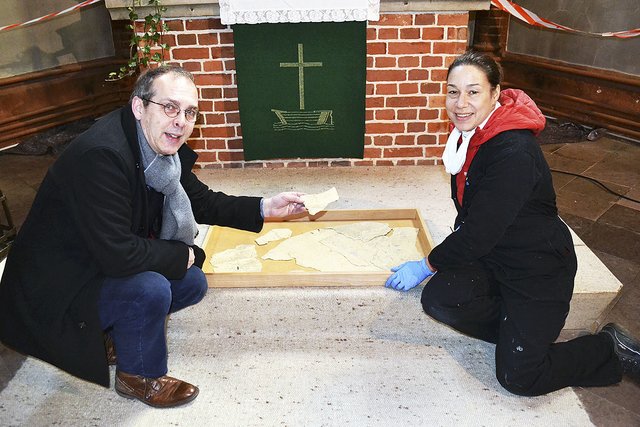 Pastor Gerald Meier und Restauratorin Christiane Maier mit den von der Altarwand abgeplatzten Schollen