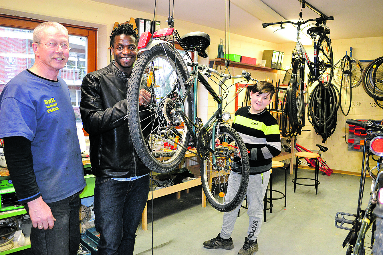 Hans-Wilhelm Wilkens mit den Fahrradwerkstatt-Besuchern Eric und und Engin (re.)