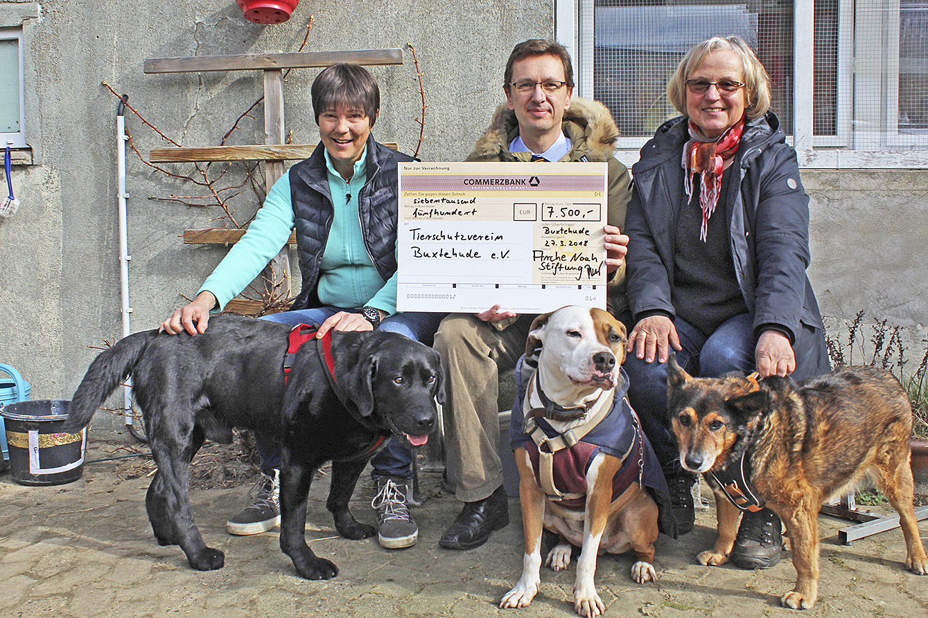 Michael Ramin von der Arche Noah Stiftung überreicht Martina Henning (li.) und Rita Sarach vom Tierschutzverein Buxtehude einen Scheck über 7.500 Euro. Auch die Hunde "Lucky", "Enni" und "Frieder" (v. li.) "sagen" Danke