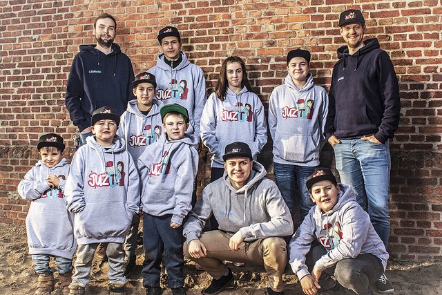 Lennard Weiß (li.) und Benjamin Gaum (re.) mit einigen jungen Besuchern in Hoodies und Caps mit dem neuen Logo