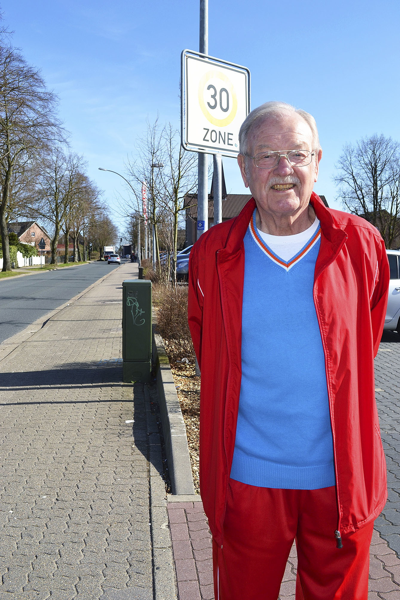 Benno Hölscher steht am einzigen 30 km/h-Schild auf dem Bade-Parkplatz. An den anderen beiden Abfahrten werden die Benutzer nicht auf die Geschwindigkeitsbeschränkung hingewiesen