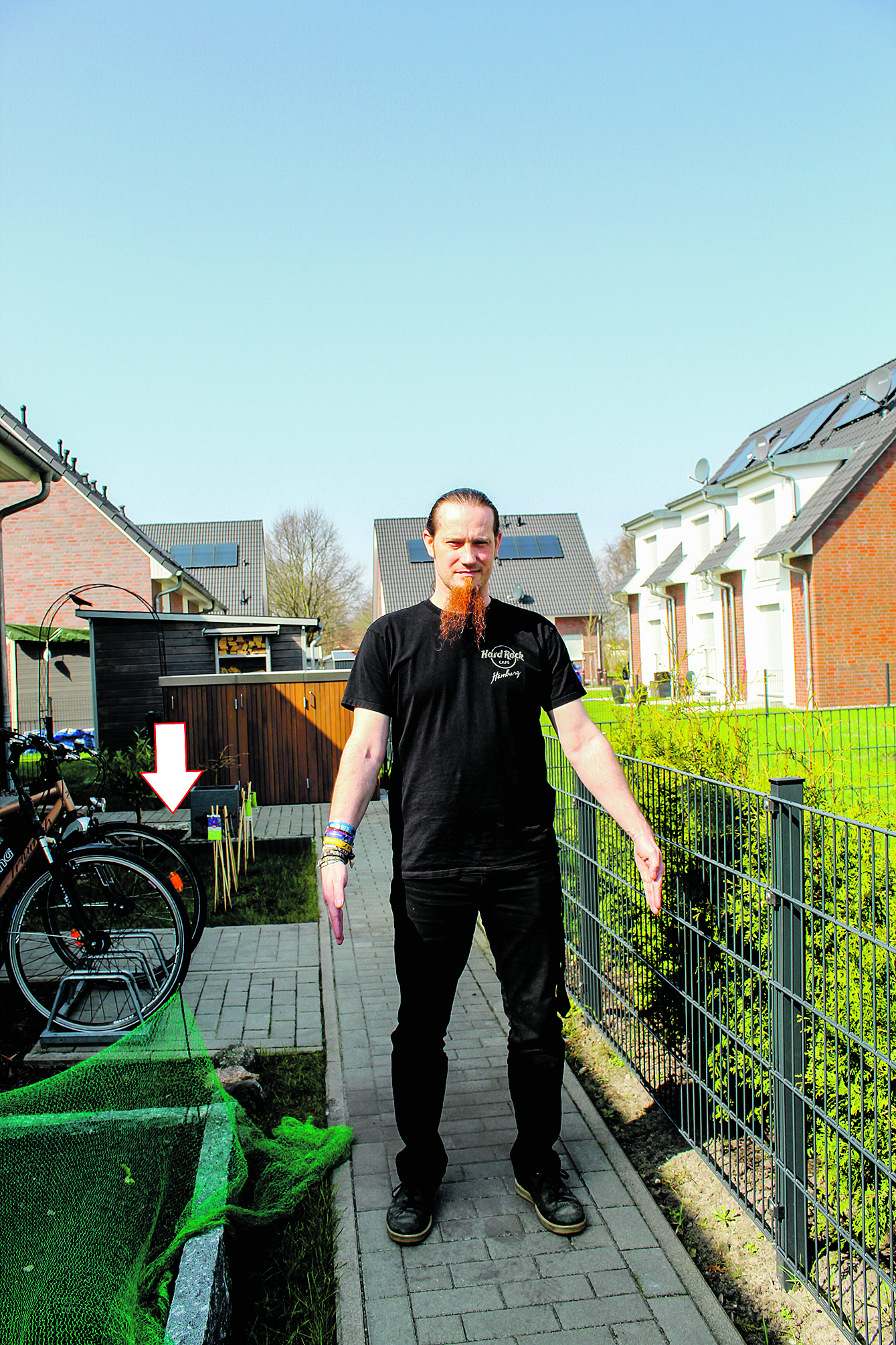 Mit seinen Armen deutet Dominic Prautzsch die Breite des Weges an. Der Pfeil markiert das Stück zu seinem Haus