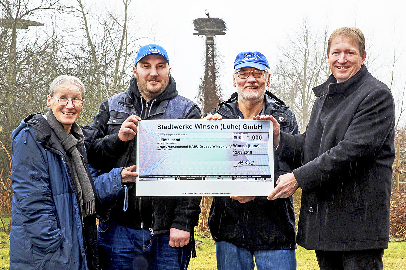Scheckübergabe vor einem Storchennest (v. li.): Ortrud Hock, Tom Sauerland, Jürgen Hülskämper und Ralph Lautenschläger