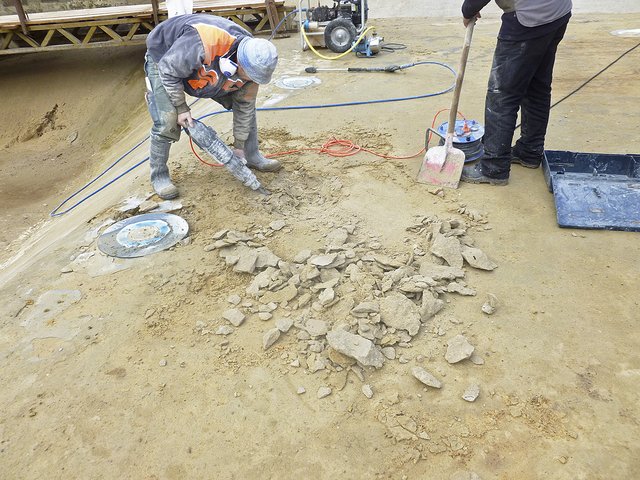 Noch sieht es im Hanstedter Waldbad nicht nach Eröffnung aus: Handwerker arbeiten an der Beckensohle