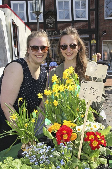 Blumenkauf auf dem Stader Wochenmarkt: die Freundinnen Lara Meyer (21, re.) aus Hemmoor und  Franziska Martens (22) aus Agathenburg mit gelb leuchtenden Osterglocken