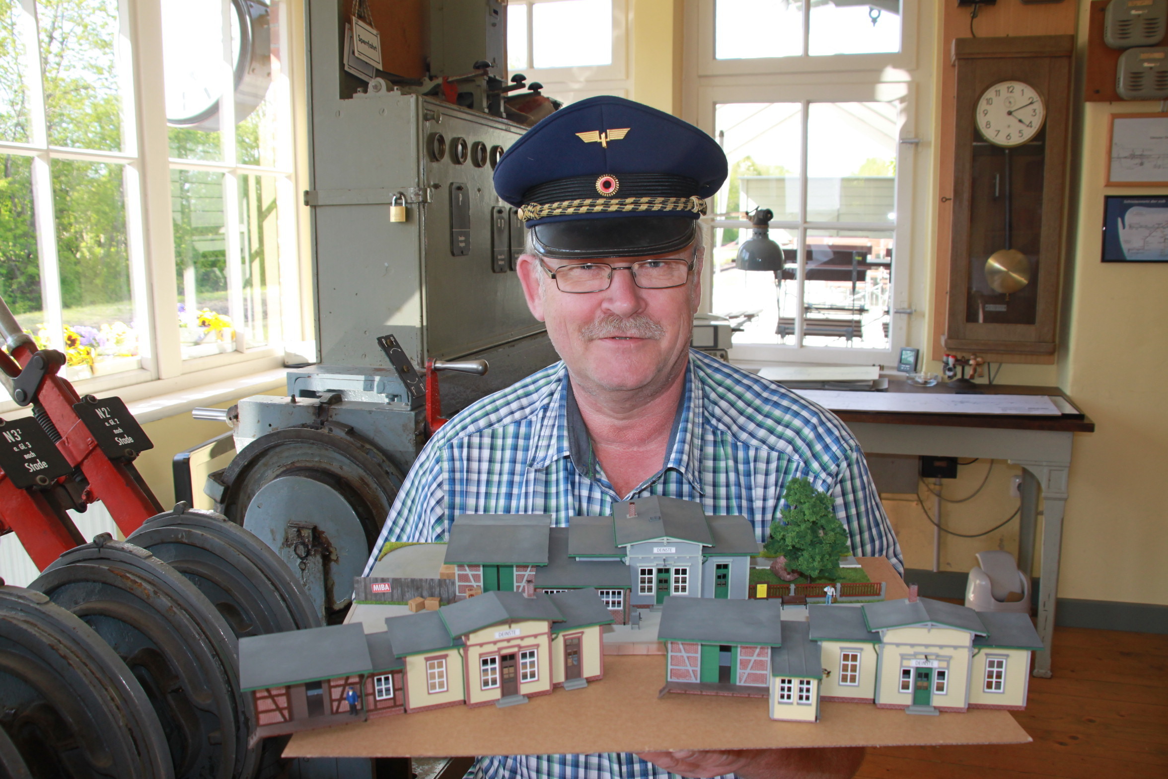 Zeigt drei Miniaturen des Bahnhofs Deinstte: Vereins-Vorsitzender Jörg Müller im Stellwerksraum