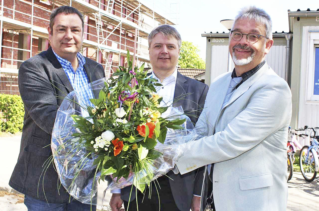 Architekt Martin Menzel (li.), hier mit Samtgemeinde-Bürgermeister Dr. Peter Dörsam, überreichte Schulleiter Friedhelm Wörner (re.) einen Blumenstrauß
