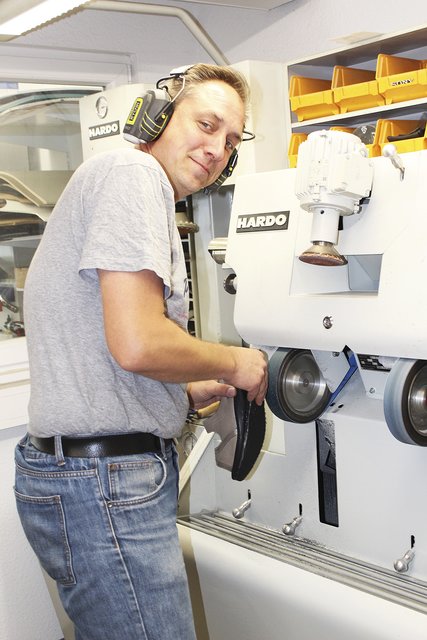 Orthopädieschuhmacher Marcus Tollmien in der Werkstatt beim Ausputzen einer Schuherhöhung