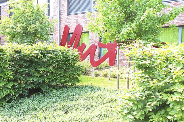 Schämt sich die Oberschule Jesteburg etwa für das "Mut"-Kunstwerk? Zumindest befindet es sich versteckt hinter hohen Hecken