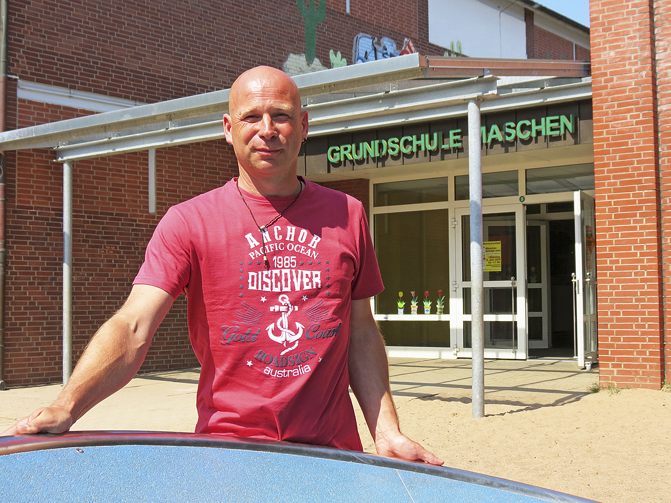 Schulleiter Rolf André vor dem Eingang der Grundschule Maschen