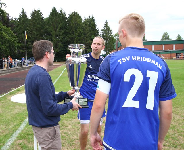 Ralf Till (Mitte) bekommt den Pott für das Siegerteam überreicht