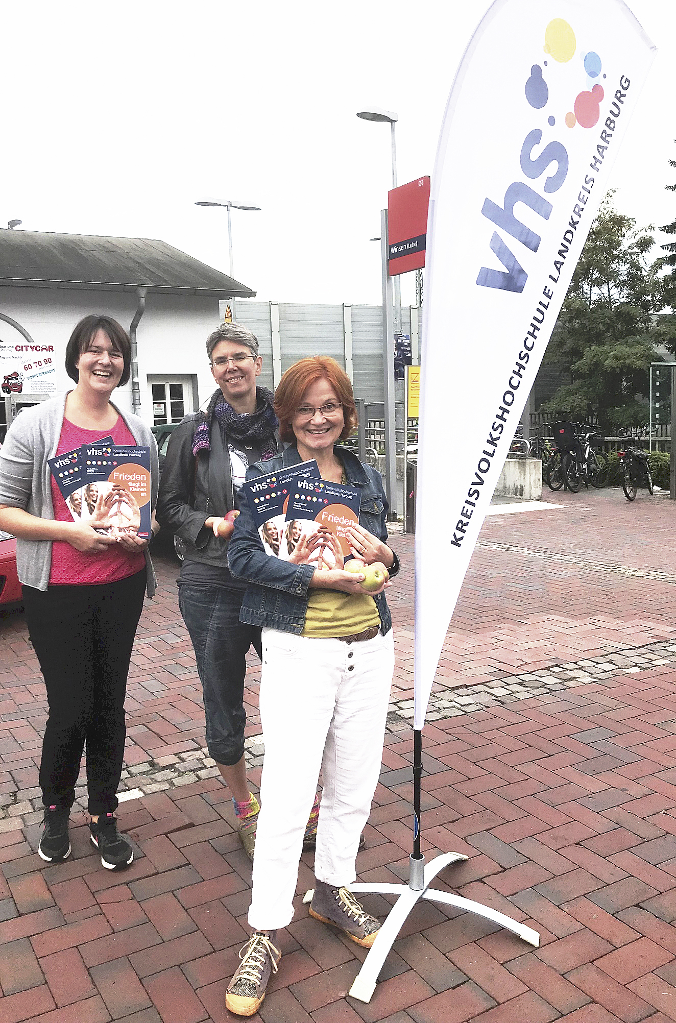 Die Mitarbeiterinnen der KVHS Landkreis Harburg Anja Wiegel (v. li.), Susanna Holtkamp und Michaela Klomp verteilten auch am Bahnhof Winsen Programmhefte und Äpfel