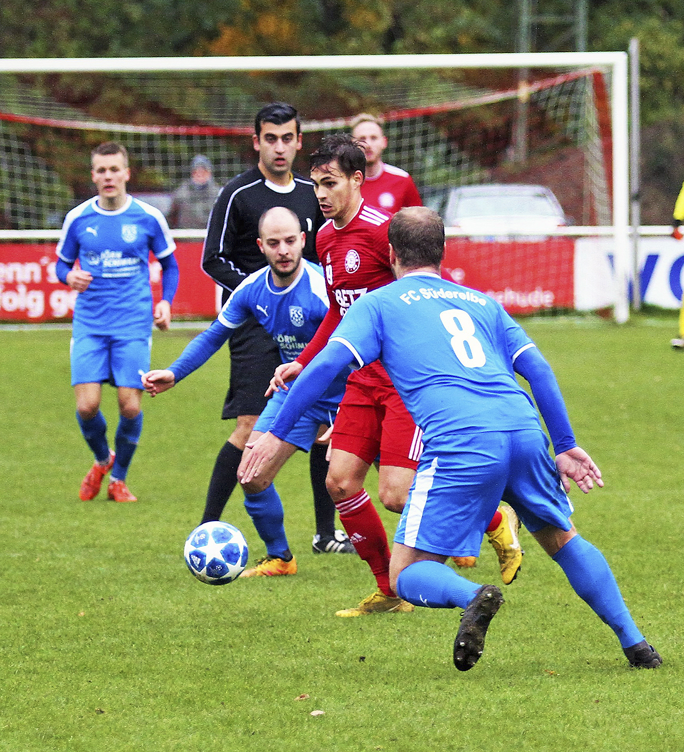 08-Mittelfeldspieler Jannik Thees (in rot) setzt sich gegen zwei Gegenspieler des FC durch