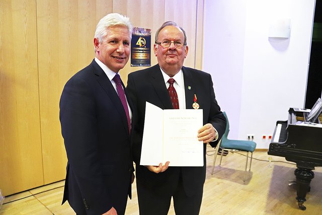 Landrat Rainer Rempe (li.) übergibt Ulf Alsguth Verdienstmedaille und Urkunde Fotos: Blasorchester Seevetal