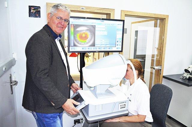 Augenoptikermeister Uwe Meins untersucht die Augen einer Kundin mit dem Visionix VX 120 Diagnostic