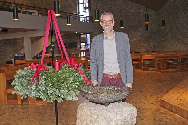 Pastor Lutz Tietje vor dem Taufstein, einem der wenigen unverrückbaren Teile in der Paulus-Kirche