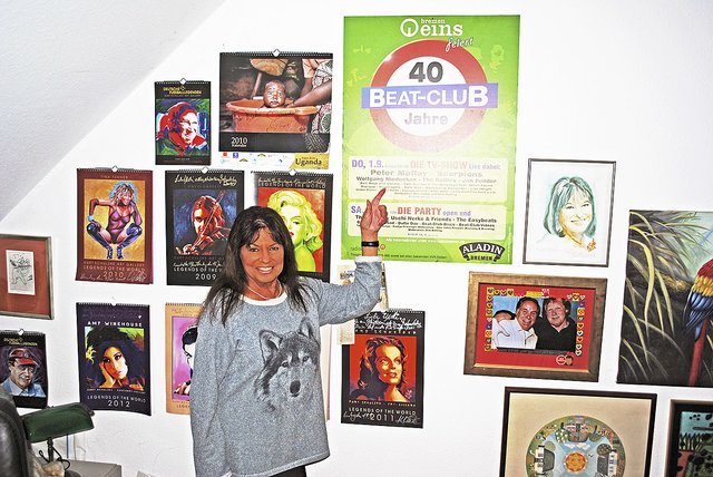 Wand voller Star-Porträts und Erinnerungen: Uschi Nerke-Petersen vor einem "Beat-Club"-Plakat und Bildern, die unter anderem der mit ihr befreundete, inzwischen verstorbene Maler Kurt Schulzke schuf Foto: ce