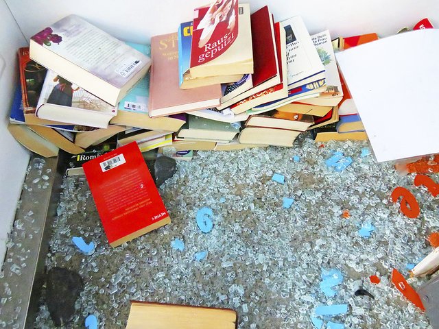 Zwei Steine und winzige Glasscherben liegen auf dem Boden