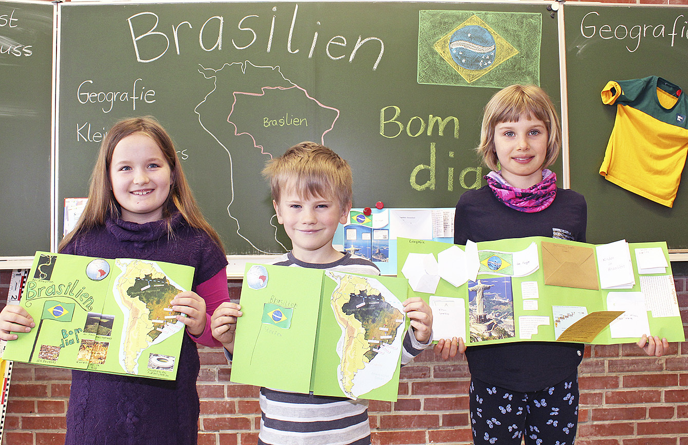 Greta (9, v.li.), Steffen (7) und Marilena (9) zeigen Lapbooks zum Thema Brasilien