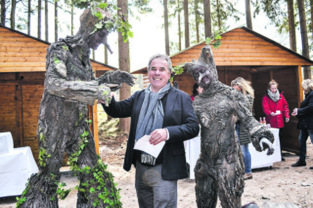 Norbert Tietz mit zwei lebenden Bäumen, die die Veranstaltung als Walking Act auflockerten